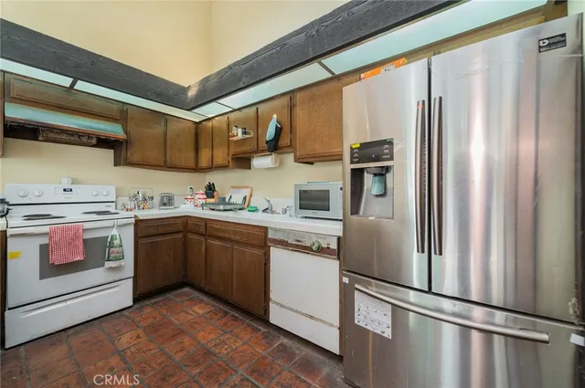 a kitchen with stainless steel appliances granite countertop a refrigerator and a stove top oven