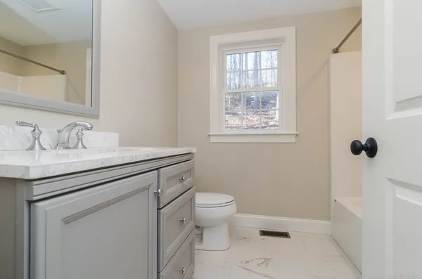 a bathroom with a sink toilet and a window