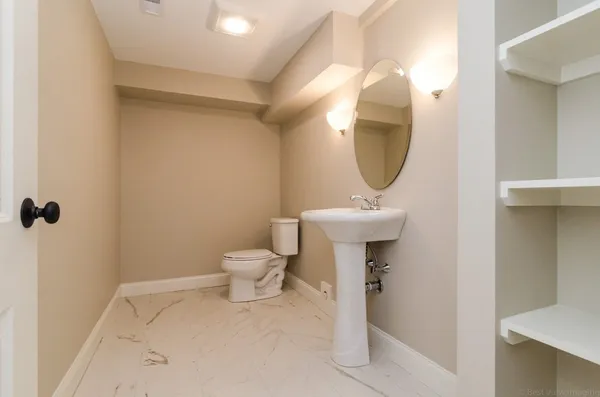 a bathroom with a sink a toilet and a mirror