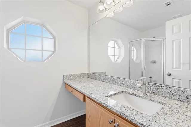 a bathroom with a granite countertop sink a mirror and vanity