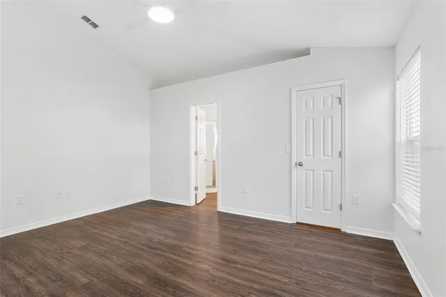 a view of an empty room with wooden floor