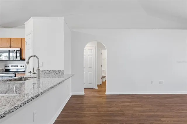 a view of a kitchen with a sink and dishwasher with wooden floor