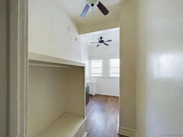a view of a kitchen with wooden floor and a ceiling fan