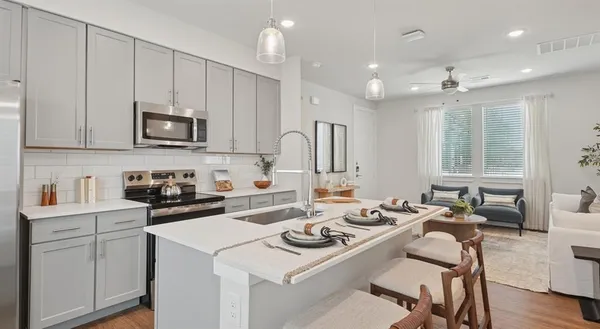 a kitchen that has a lot of cabinets a sink and a stove in it