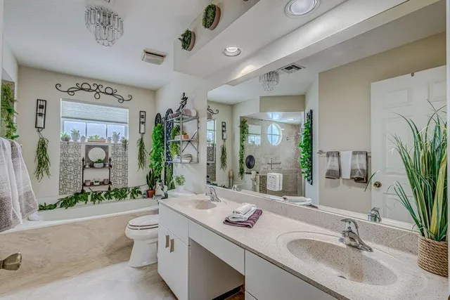 a bathroom with a granite countertop sink vanity mirror bathtub shower and a toilet