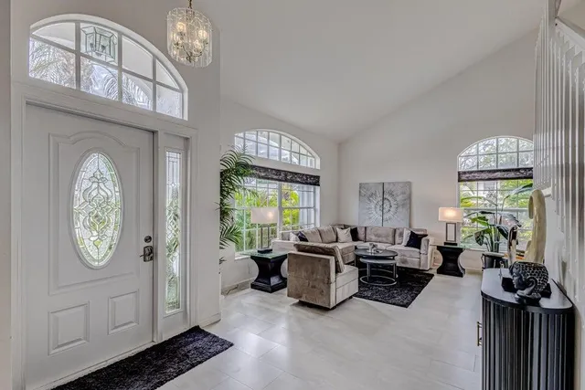 a living room with furniture a chandelier and a large window