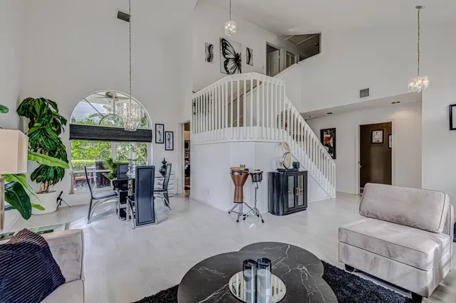 a living room with furniture a chandelier and a flat screen tv