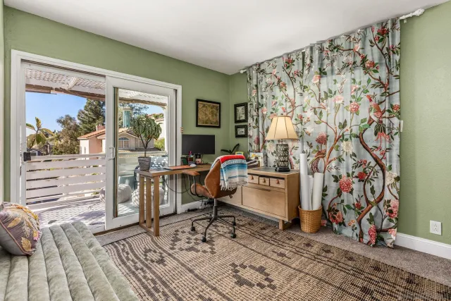 a bed sitting in a bedroom next to a window and a chair