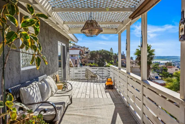 a porch with a bench next to a yard