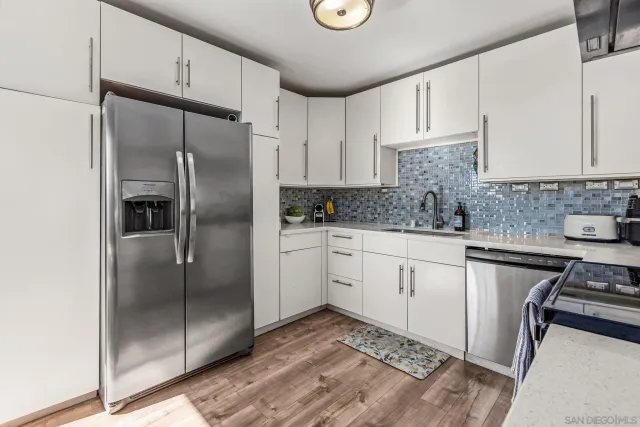 a kitchen with white cabinets stainless steel appliances and sink