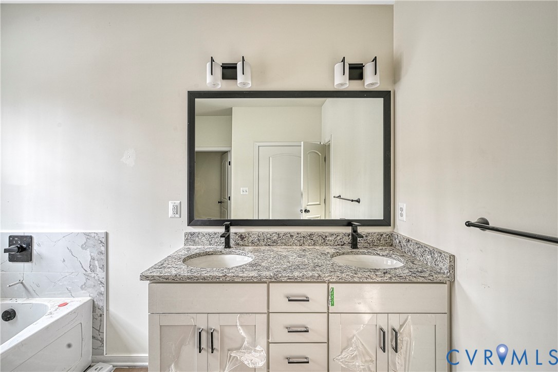 925 Moody Town Road Bumpass, VA 23024 - Photo 26 of 47 a bathroom with a granite countertop sink a mirror and a
