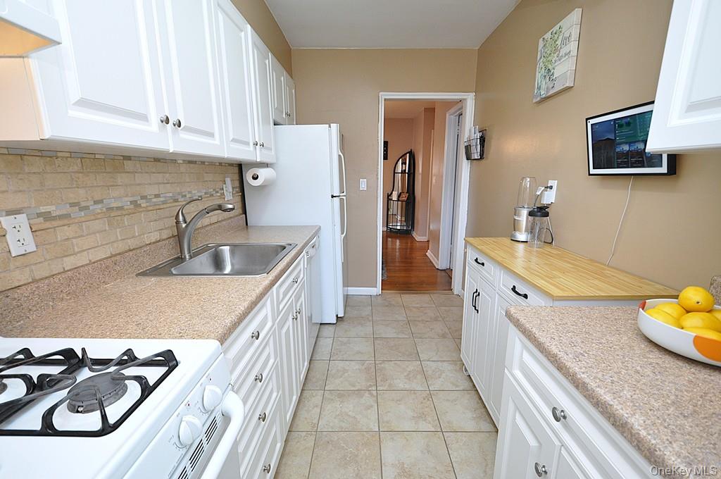 1 Vincent Road, Unit 6B Bronxville, NY 10708 - Photo 7 of 28 a kitchen with stainless steel appliances granite countertop a sink stove and refrigerator