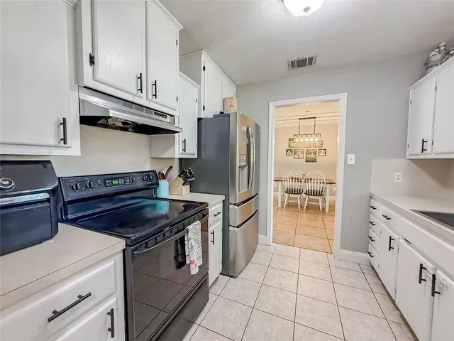 a kitchen with granite countertop a stove sink and refrigerator