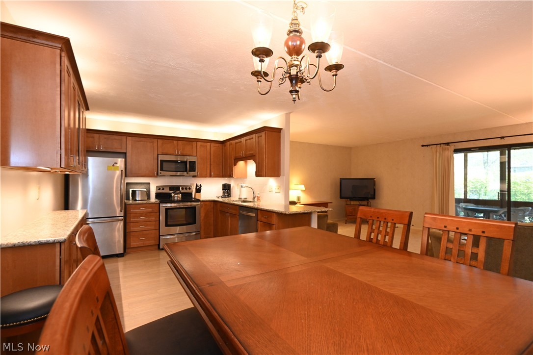 22962 Maple Ridge Road, Unit 108 North Olmsted, OH 44070 - Photo 17 of 37 Dining space featuring an inviting chandelier, light hardwood / wood-style floors, and sink
