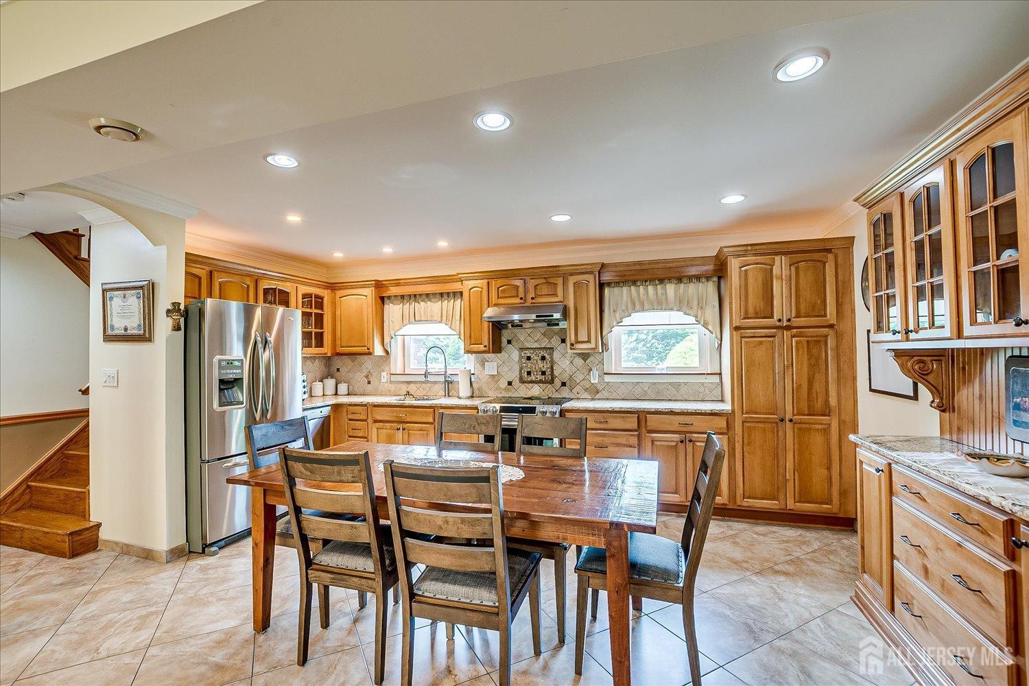 807 New Dover Road Edison, NJ 08820 - Photo 31 of 41 a dining room with stainless steel appliances kitchen island granite countertop a table chairs and a refrigerator