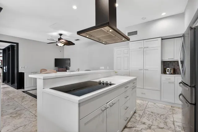 a bedroom with a large bed and a chandelier fan