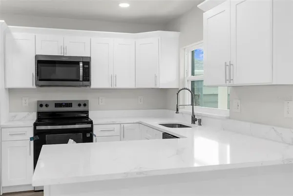 a kitchen with granite countertop a sink and a stove top oven