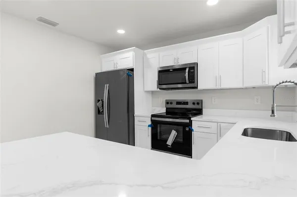 a kitchen with stainless steel appliances a refrigerator stove microwave and sink