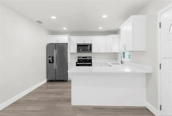 a kitchen with stainless steel appliances a refrigerator stove microwave and sink