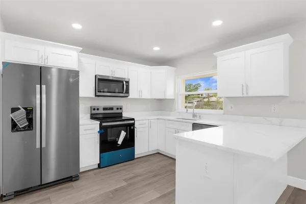 a kitchen with a refrigerator sink and stove top oven
