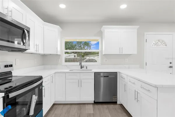 a kitchen with a sink stove and microwave