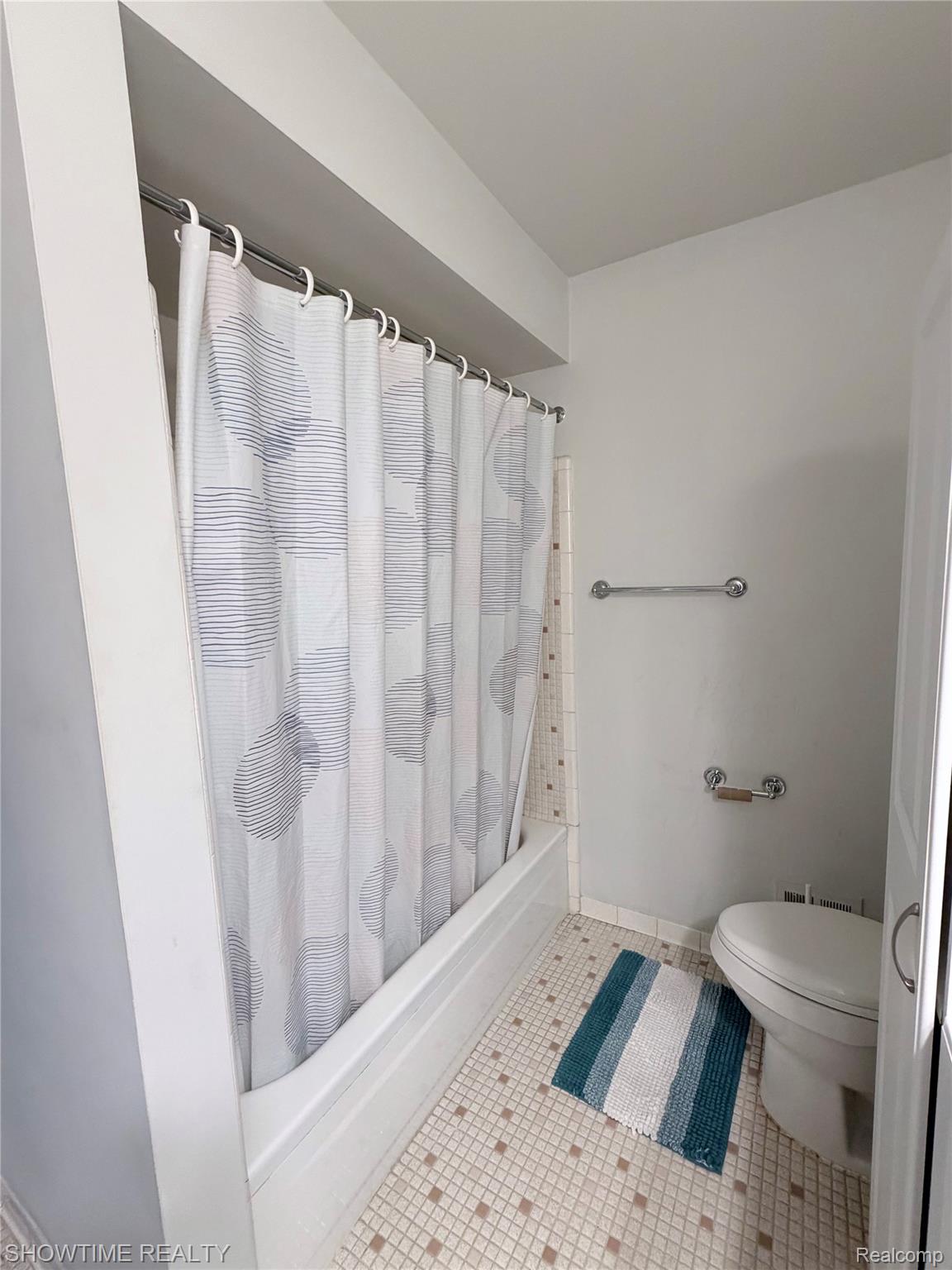 29117 Hayes Road, Unit 3 Warren, MI 48088 - Photo 14 of 14 Full bathroom featuring a white bathtub with shower, tiled walls, and a toilet