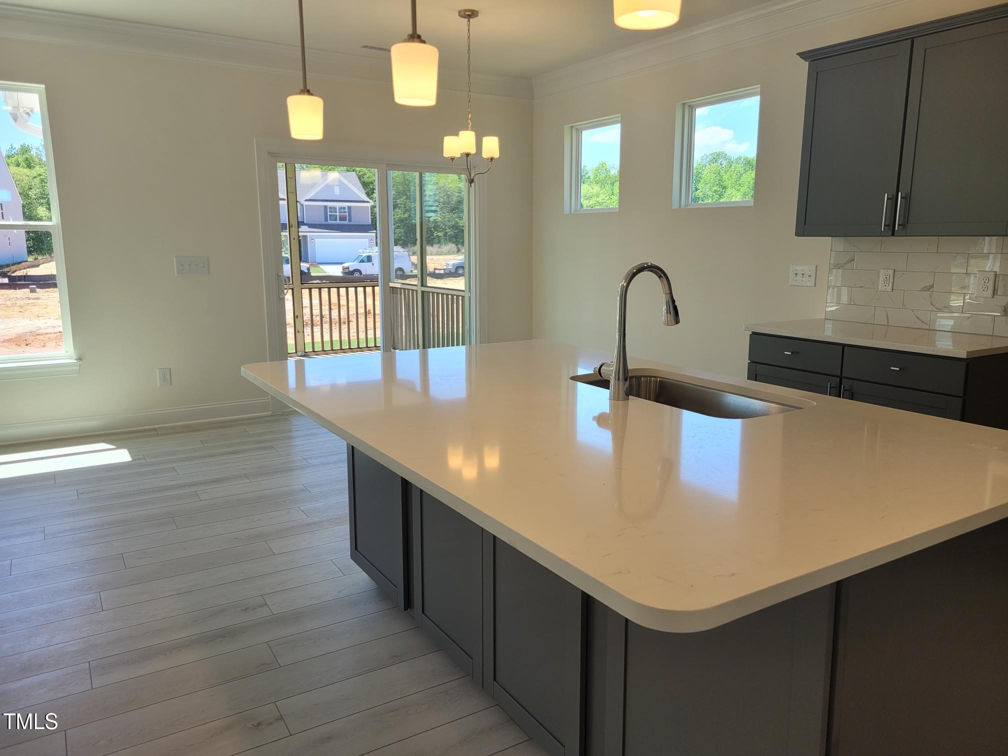 3703 Cessna Way, Unit 9 Wilson, NC 27896 - Photo 2 of 16 a kitchen with kitchen island a sink and wooden floor