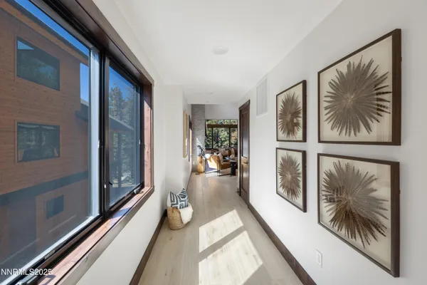 a view of a hallway with furniture and floor to ceiling window