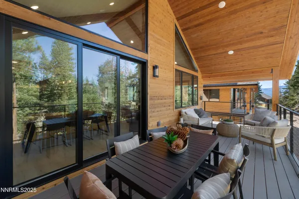 a view of a patio with table and chairs and wooden floor