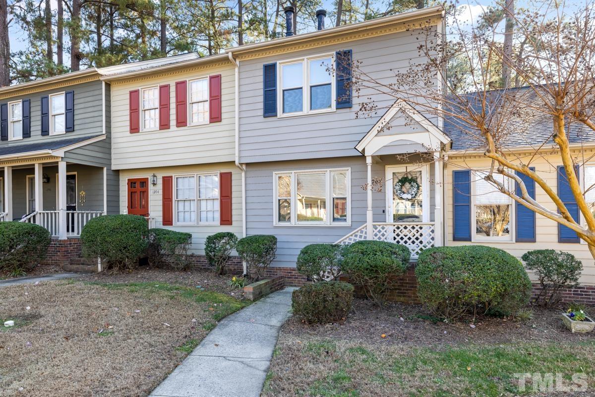 1202 Shadow Bark Court Raleigh, NC 27603 - Photo 2 of 27 a view of a brick house with large windows and a yard