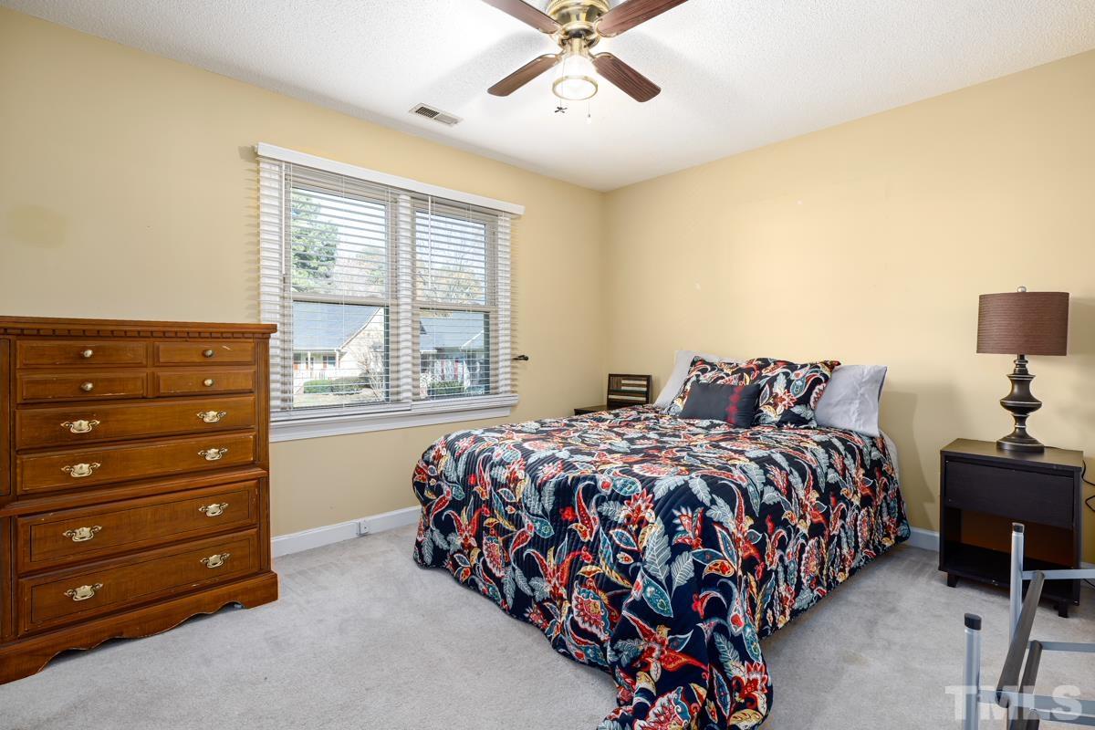 1202 Shadow Bark Court Raleigh, NC 27603 - Photo 18 of 27 a bedroom with a bed and window with lamp