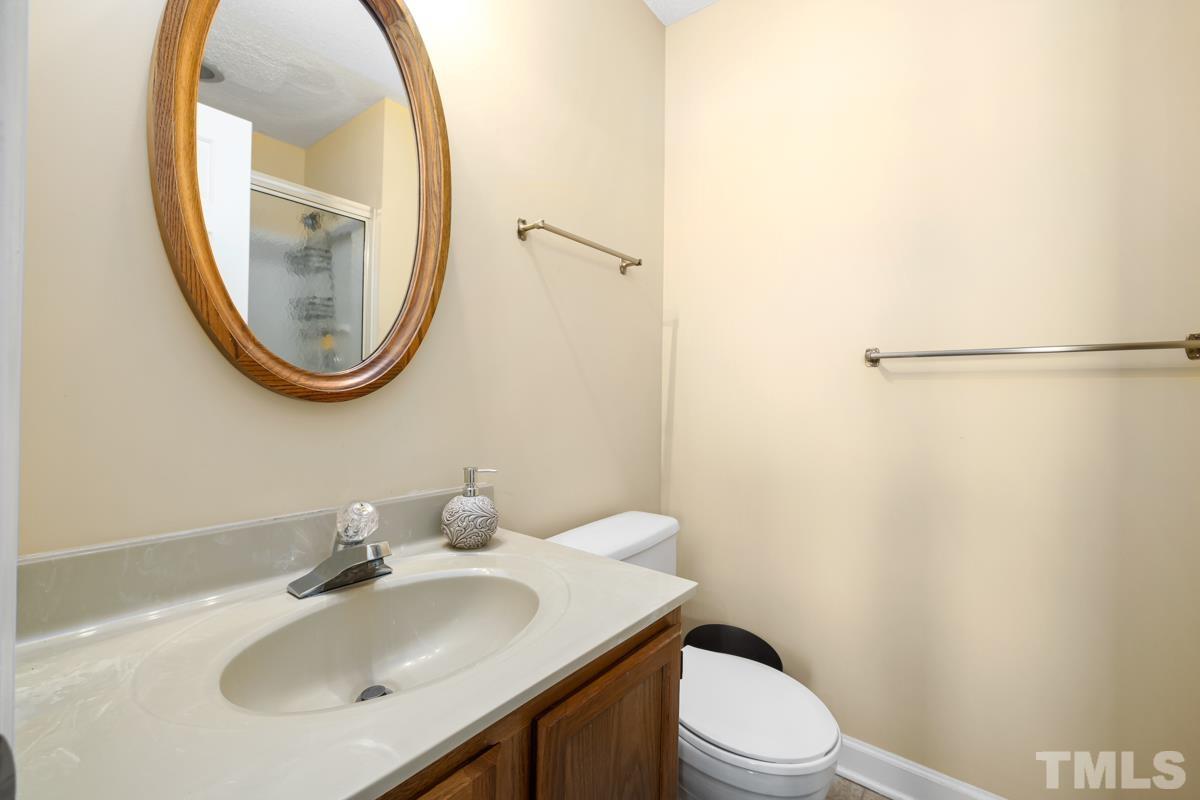 1202 Shadow Bark Court Raleigh, NC 27603 - Photo 20 of 27 a bathroom with a sink a toilet and a mirror