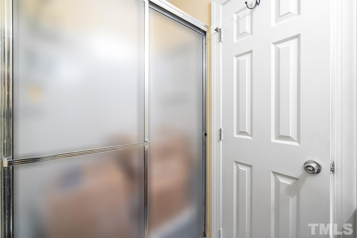 1202 Shadow Bark Court Raleigh, NC 27603 - Photo 21 of 27 a bathroom with a glass shower door