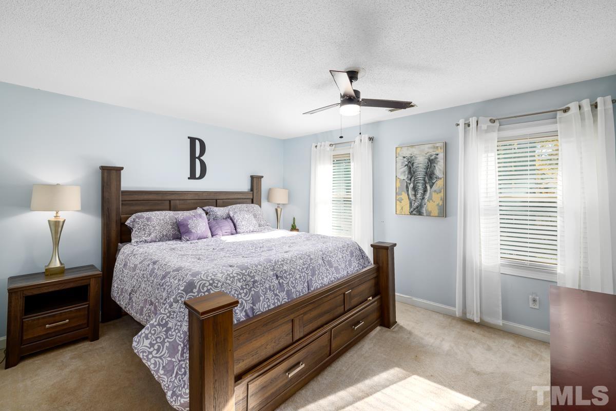 1202 Shadow Bark Court Raleigh, NC 27603 - Photo 23 of 27 a bed room with a bed and a chandelier