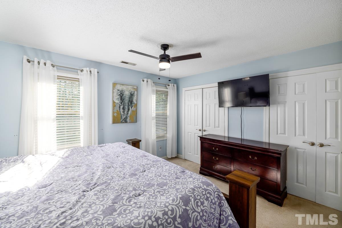 1202 Shadow Bark Court Raleigh, NC 27603 - Photo 25 of 27 a bedroom with a bed and a flat screen tv