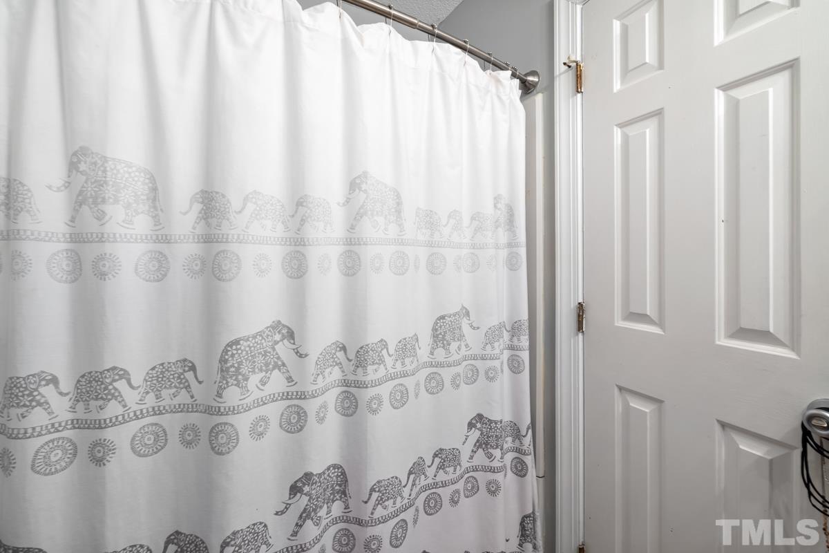 1202 Shadow Bark Court Raleigh, NC 27603 - Photo 26 of 27 a bathroom with a shower curtain and a shower curtain