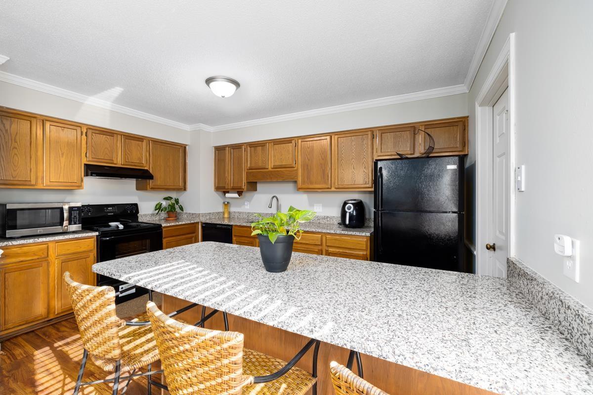 1202 Shadow Bark Court Raleigh, NC 27603 - Photo 9 of 27 a kitchen with stainless steel appliances granite countertop a refrigerator a stove top oven a sink dishwasher and white cabinets with wooden floor