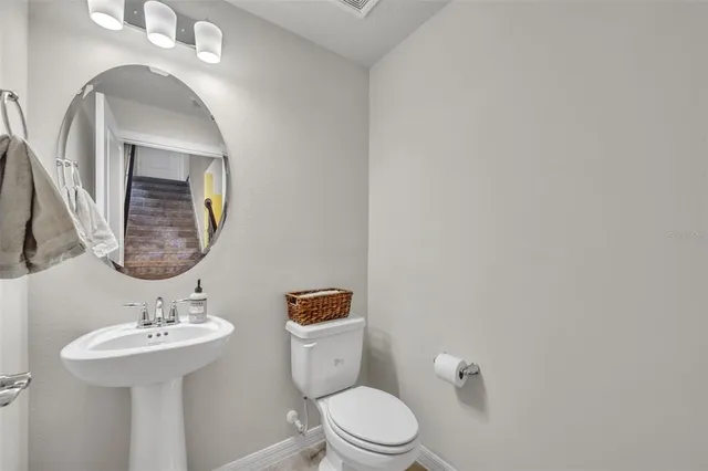 a bathroom with a toilet a sink and mirror