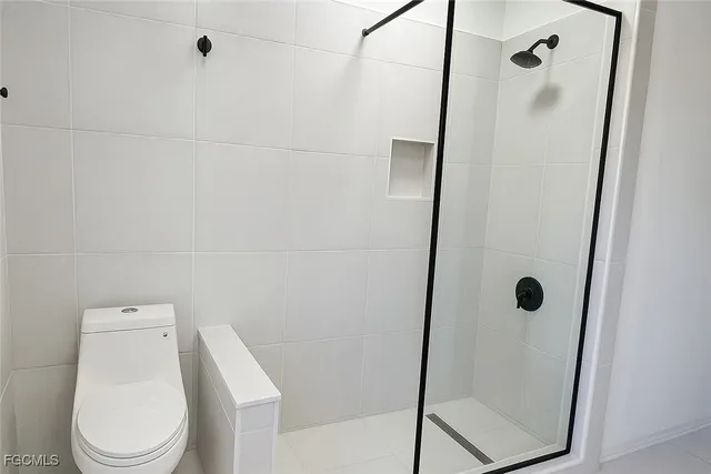 a white toilet sitting next to a shower