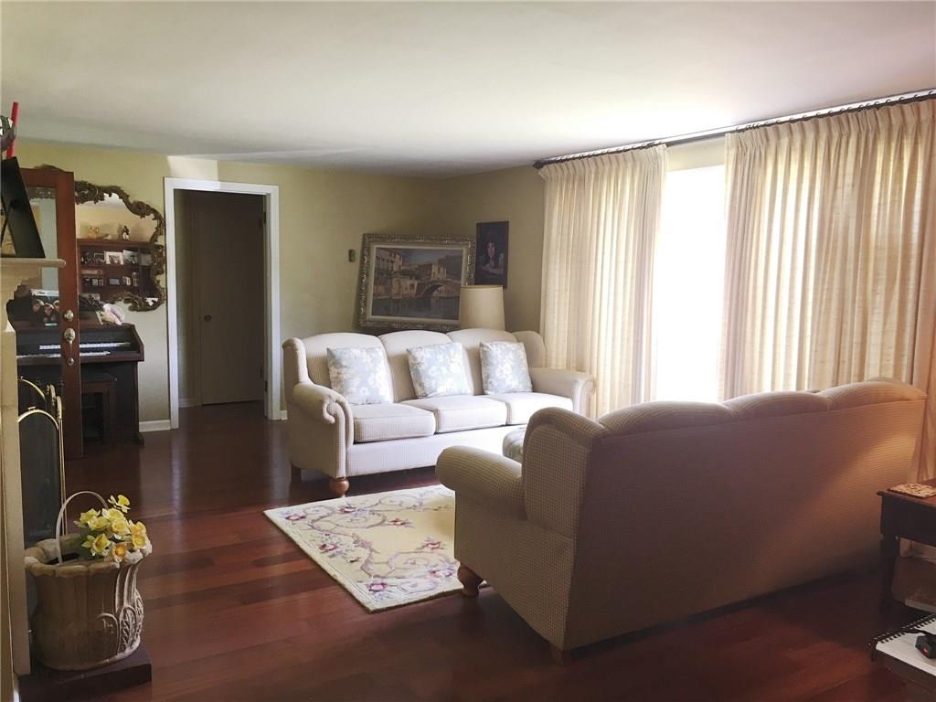2859 Brodhead Road Aliquippa, PA 15001 - Photo 2 of 23 LIVING ROOM - Large open space with wood burning fireplace to the left and open door to bedrooms straight ahead. Large picture window brings in plenty of sun. Newer hardwood floors.