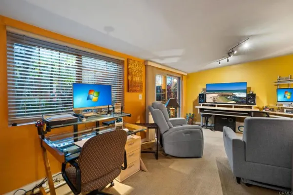 a living room with furniture a flat screen tv and a floor to ceiling window
