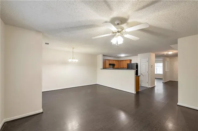a view of a livingroom with a ceiling fan window and wooden floor