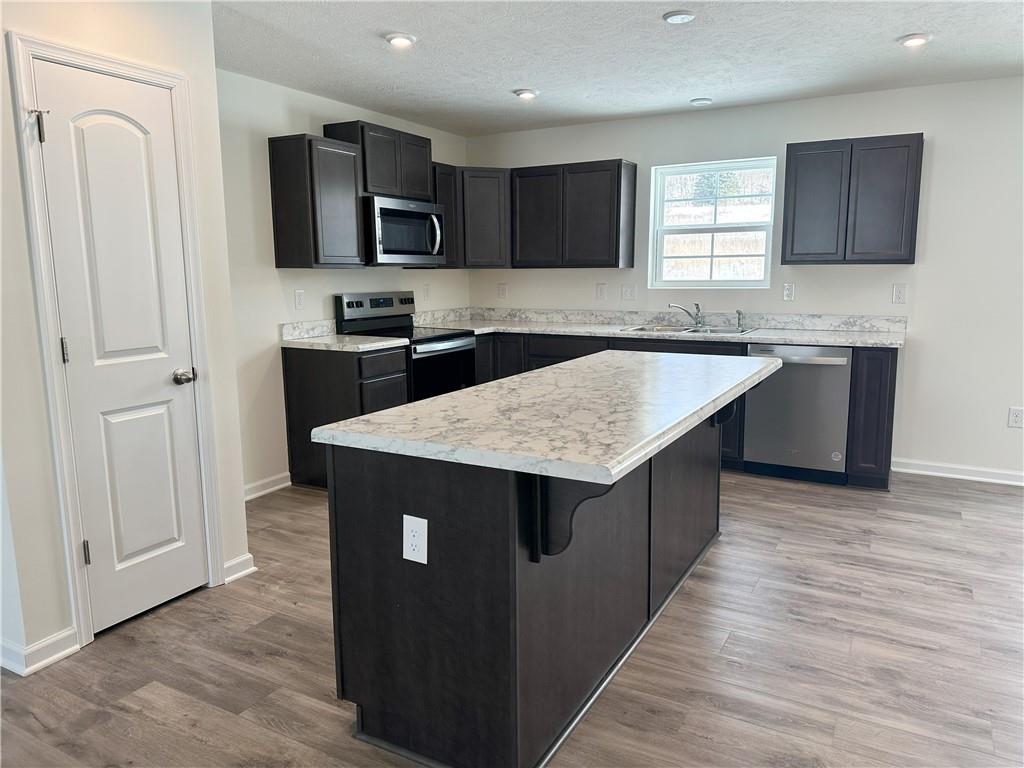 121 Marginal Road Hunker, PA 15639 - Photo 7 of 34 a kitchen with stainless steel appliances granite countertop a sink stove microwave and refrigerator