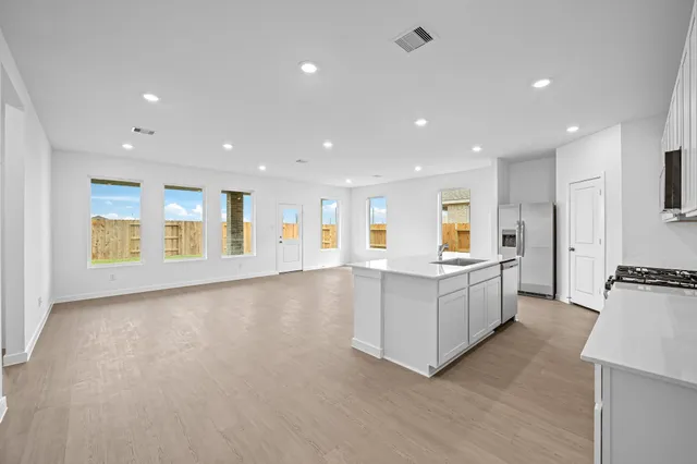 a large white kitchen with lots of counter space and stainless steel appliances