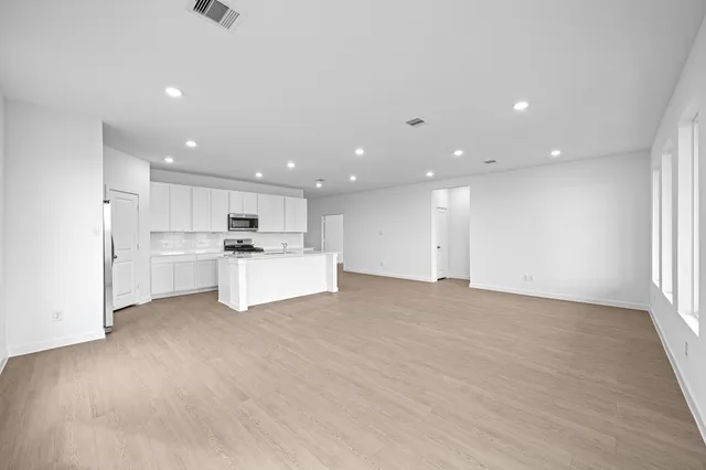 a view of kitchen with kitchen island and stainless steel appliances