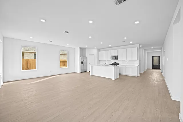a view of a kitchen with a sink stainless steel appliances cabinets and a window