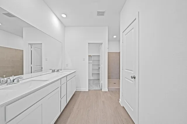 a bathroom with a double vanity sink a mirror and a shower