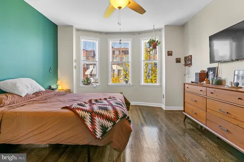 a bedroom with a bed and wooden floor