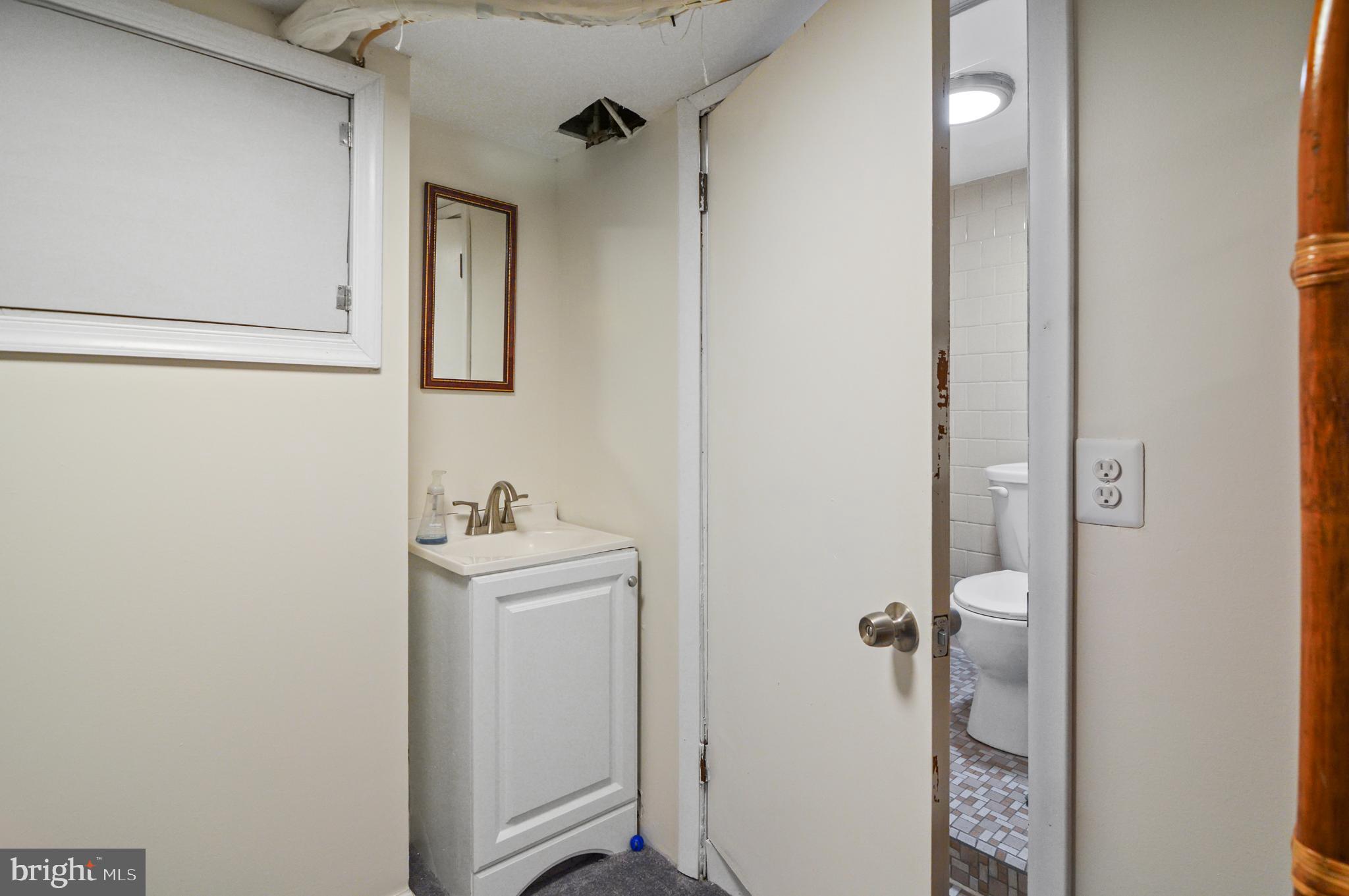 505 South Lehigh Street Baltimore, MD 21224 - Photo 21 of 25 a bathroom with a sink and mirror with toilet