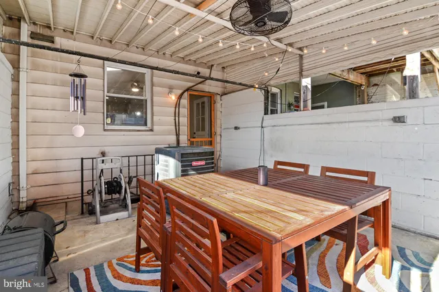 a view of a patio with table and chairs with wooden floor and fence